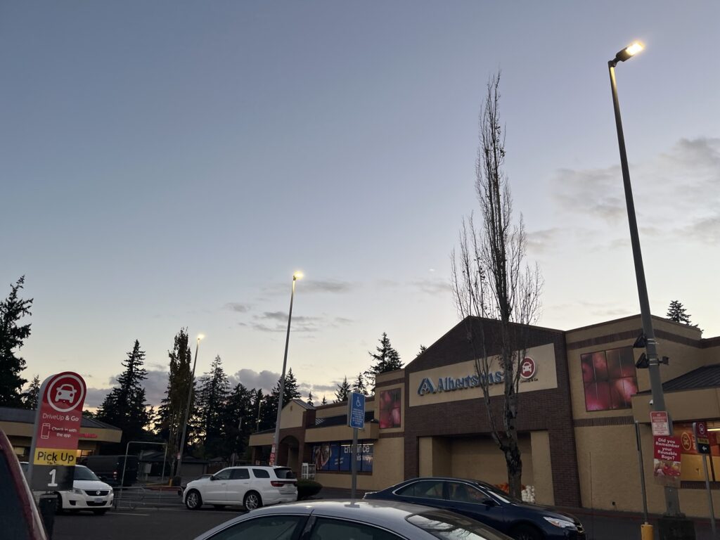 An Alberston's store front from the parking lot, with the darkening evening sky hanging above it.